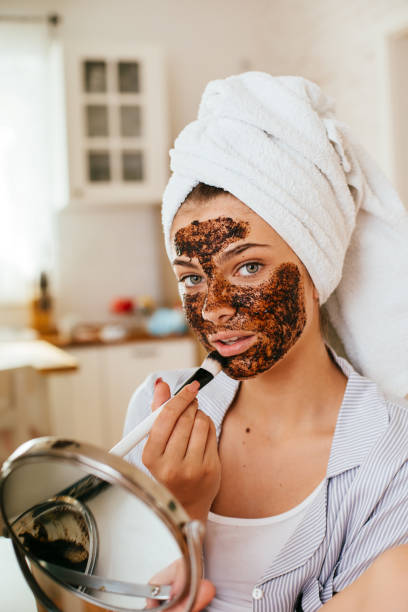 istock Young woman applying coffee scrub on her face 2170652350
