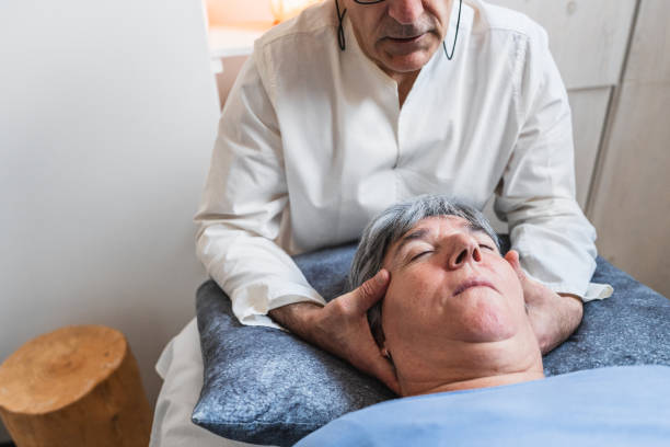 istock Therapist performing craniosacral therapy, gently cradling patient's head for relaxation and healing. 2170652395