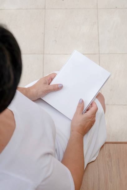 istock unrecognizable woman holding blank magazine for mockup design, sitting on bench 2170652592