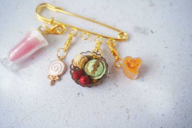 istock miniature drink and cake attached to a gold brooch 2170652897