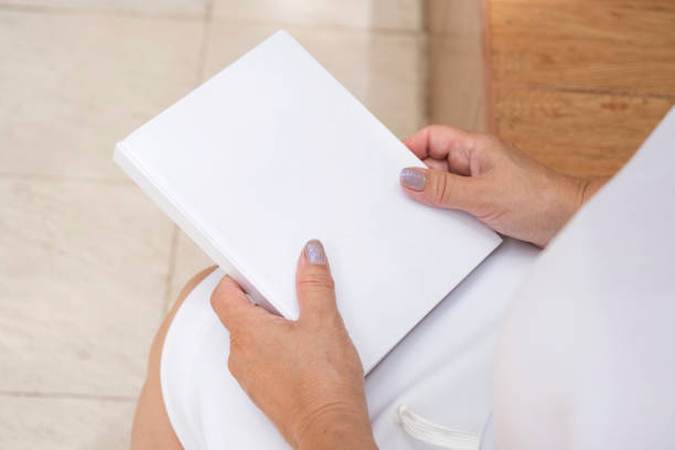 istock unrecognizable woman holding blank magazine for mockup design, sitting on bench 2170653862