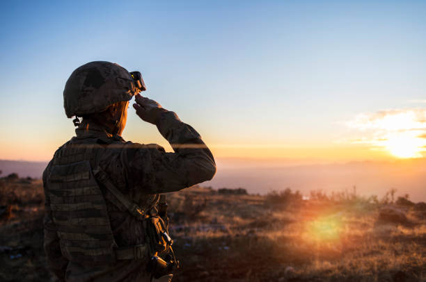 istock Female Army Solider Saluting against sunset sky 2170655183