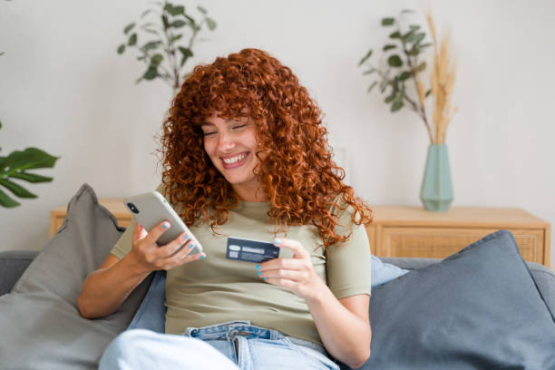 istock Happy woman using smartphone for online shopping on sofa at home 2170656000