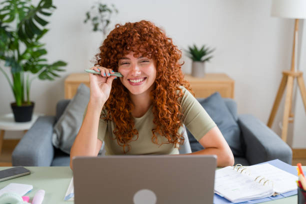 istock Happy freelancer woman holding pen working from home using laptop computer 2170656689