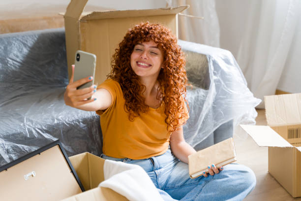 istock Happy woman taking selfie while moving into new apartment 2170657153