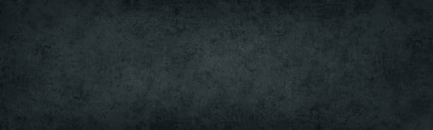 istock Black concrete wall. Dark old shabby rough cement panoramic distressed texture. Gloomy grunge textured long banner background 2170657511