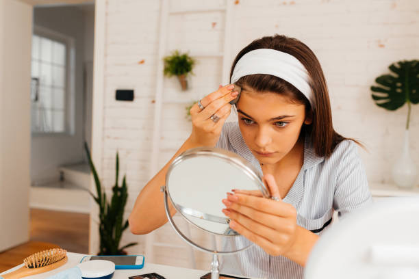 istock Young woman cleaning her face with lotion 2170657531