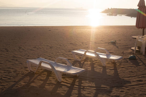 Beach chairs on the beach at sunrise.