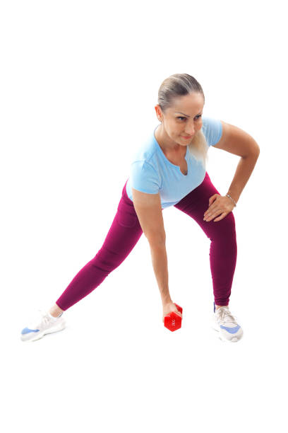 Focused woman doing a side lunge with a red dumbbell, targeting leg strength and flexibility, isolated on a white background.