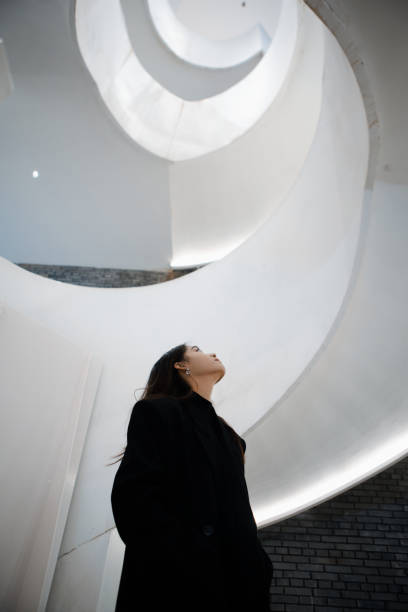 a beautiful woman is walking and shopping on the spiral staircase - detailhandel fotos stockfoto's en -beelden