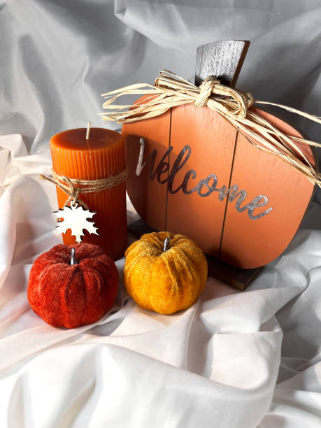istock Orange pumpkins, lantern and walnuts on a white textile background. 2170662864