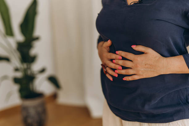 istock A woman places her hands on her stomach, performing external techniques as part of chiropractic diaphragmatic breathing. 2170666708