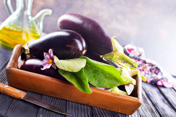 istock Raw eggplants ( aubergines ) in wooden box. Selective focus 2170667042