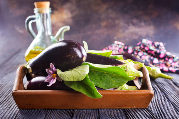 istock Raw eggplants ( aubergines ) in wooden box. Selective focus 2170667043