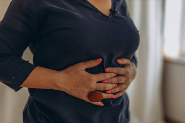 istock A woman places her hands on her stomach, performing external techniques as part of chiropractic diaphragmatic breathing. 2170667435