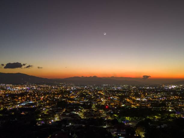 istock Cityscape at dusk with crescent moon and sunset sky. 2170667546