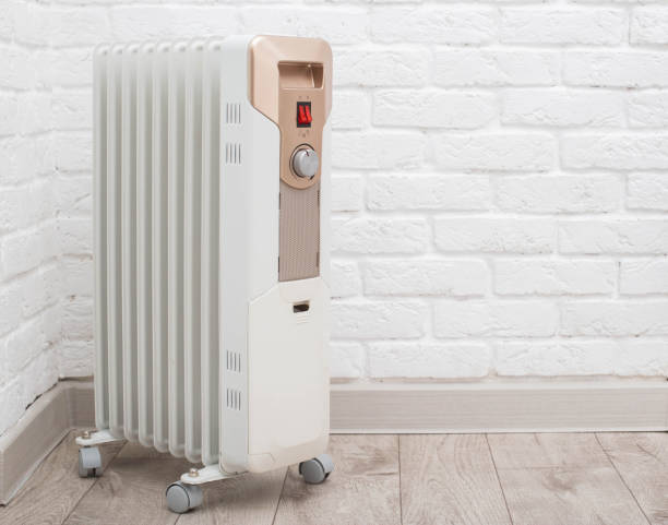 istock Electric heating radiator with temperature control on the background of a white brick wall. The concept of heating a room without turning on the heating in the apartment. The cold season is autumn and winter. Copy space for text 2170668315