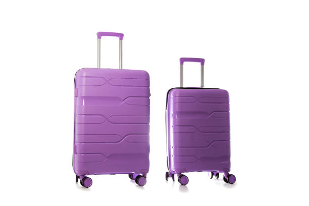Set of polypropylene purple suitcases on a white background, isolate