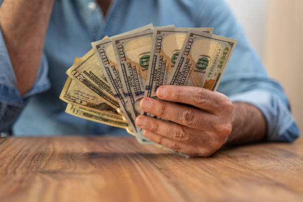 istock Freelancer accountant holds dollar banknotes in hands counting weekly income for providing services 2170672318