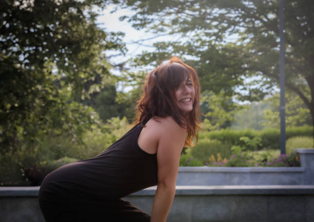 Woman posing elegantly at a photo shoot in a well-kept park