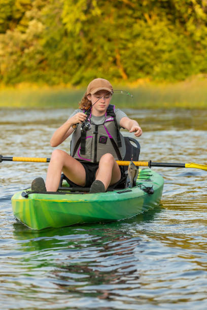 istock Girl Catching Fish While Kayak Fishing 2170674391