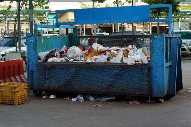 istock A large metal trash can is placed in the parking lot. 2170681493
