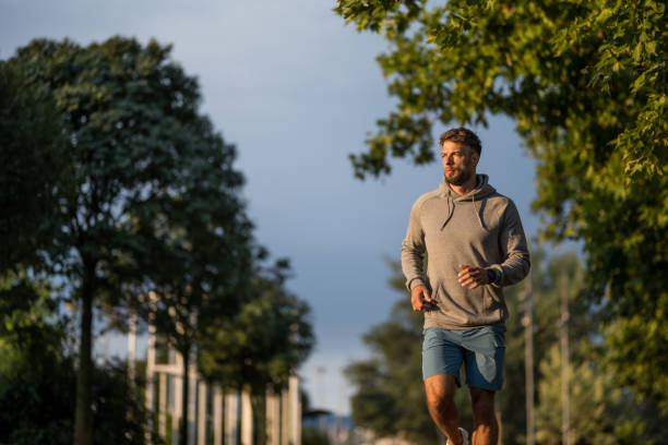 istock Athletic man running outdoors in the park in the morning. 2170687040