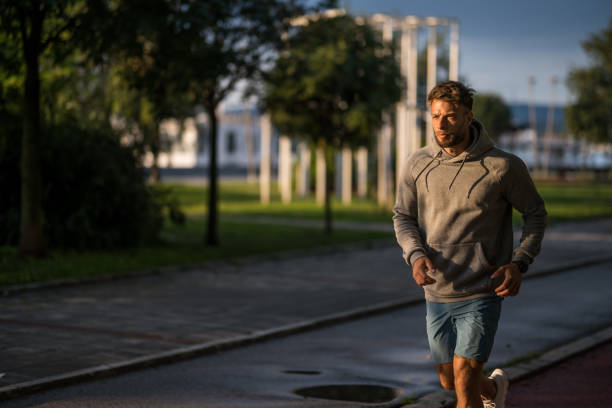 istock Athletic man running outdoors in the park in the morning. 2170687198