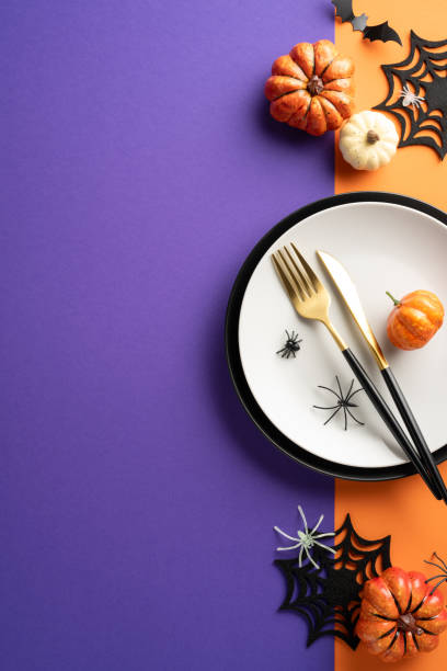 istock Halloween vertical table setting with pumpkins, spider decorations, and cutlery on a purple and orange background 2170688127