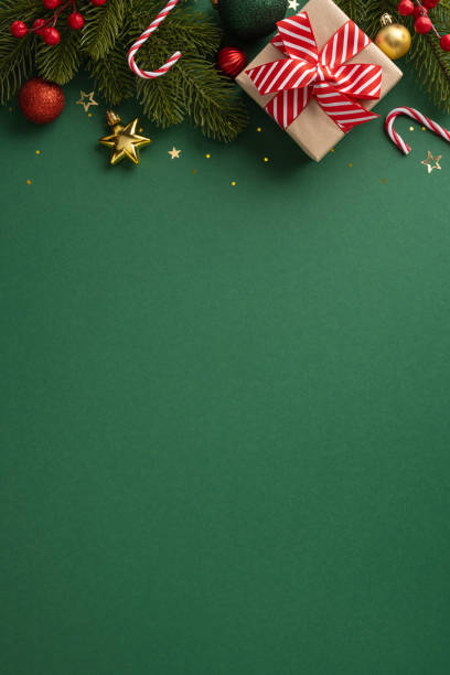 istock Beautiful Christmas vertical background with a wrapped gift, candy canes, and festive decorations on a green surface 2170688147