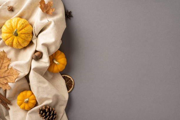 istock Cozy autumn scene featuring small pumpkins, leaves, and natural elements on a beige fabric. Perfect for harvest, thanksgiving, and fall themes 2170688172