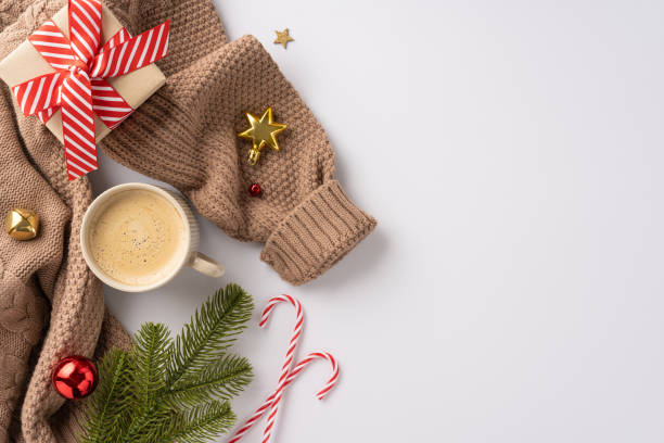 istock Warm holiday season image featuring a cozy sweater, coffee, gift, candy canes, and festive decorations 2170688190