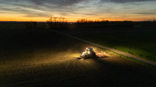 istock Illuminated Tractor on Field at Dusk 2170690593
