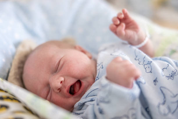 istock Close-Up of Newborn Boy Yawning while Sleeping in Crib 2170690642