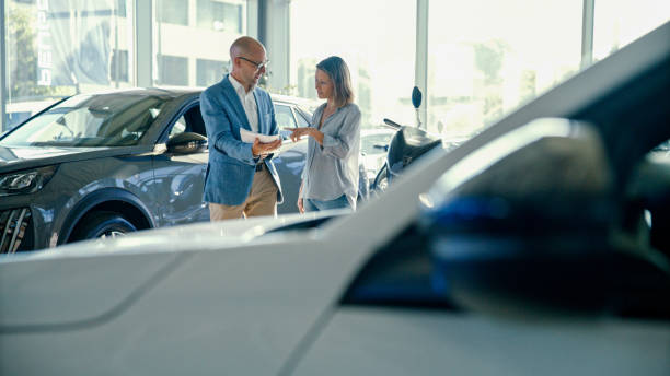 istock White Car with Customer and Salesperson Discussing Documents in the Background 2170691893