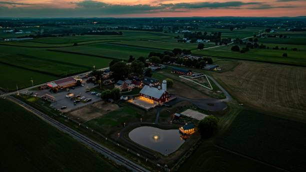 istock Tranquil Farm Scene At Dusk Featuring A Large Red Barn With White Silo, Illuminated Stone Courtyard, 2170696723