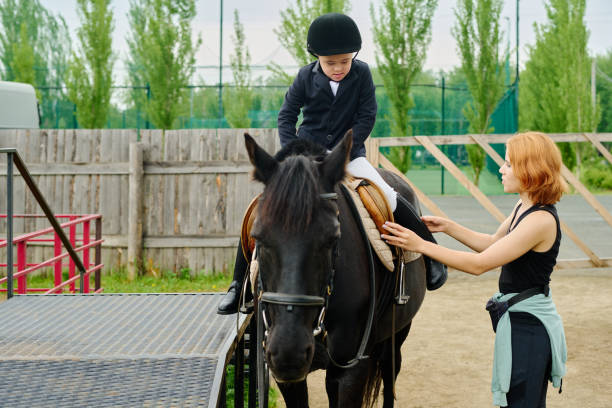 istock Assisting Young Horse Rider During Equestrian Training 2170700470