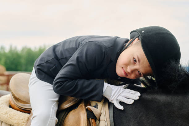 Young Boy Petting Horse while Sitting on Saddle