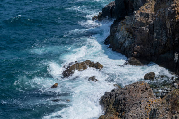 Waves crashing into rocks in the ocean.