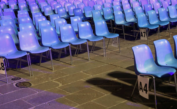 many empty blue plastic chairs without people before the start of a live concert