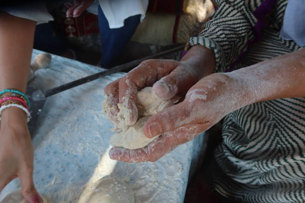 istock Female hands using flour in baking dough to make bread 2170717357