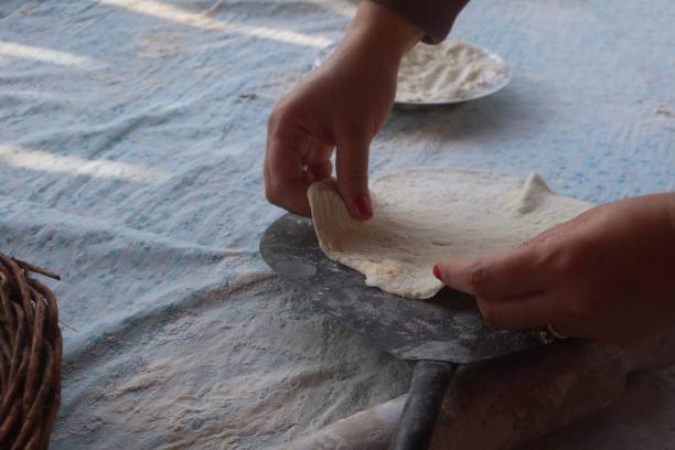 istock Female hands using flour in baking dough to make bread 2170718273