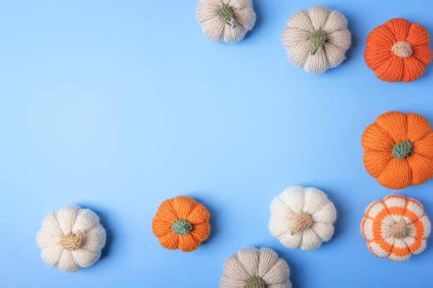 istock Knitted pumpkins on blue background 2170720525