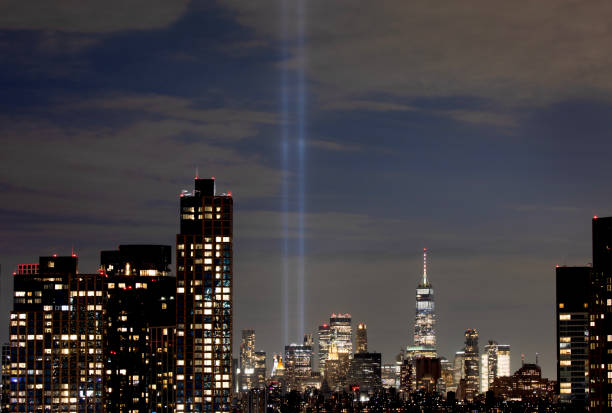 Tribute lights illuminated with the New York City skyline