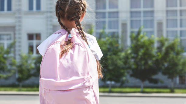 istock Little girl with backpack going to school, back view. Back to school 2170721340