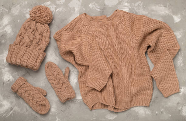 istock Sweater and winter hat with mittens on concrete background, top view. 2170729046