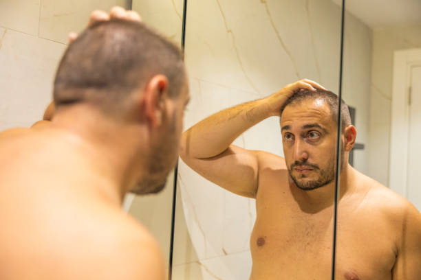 istock Men is looking at the mirror in the bathroom. 2170733950