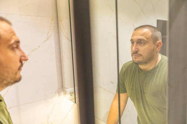 istock Men is looking at the mirror in the bathroom. 2170734486