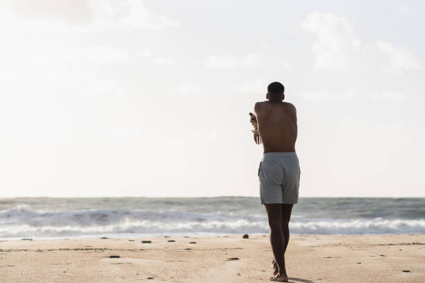 istock Young black man stretching on the beach 2170742617