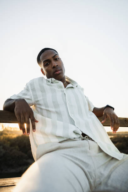 istock Young man sitting and relaxing by the water at sunset 2170742620